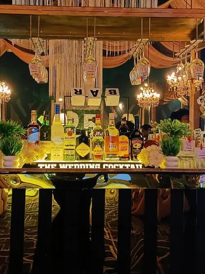 A rustic-chic bar with a mirrored front and macrame details, perfect for a bohemian or outdoor wedding setting.