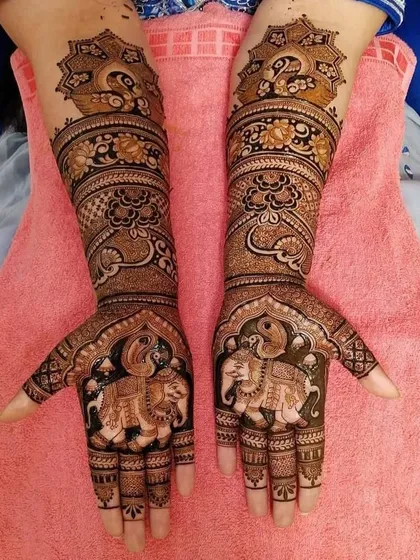 This is a classic example of traditional Indian mehndi, with majestic elephants on the palms and graceful peacocks on the forearms, symbolizing prosperity and beauty.