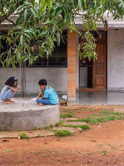 The farmhouse was designed to be inconspicuous and uncomplicated, nestled among the mango trees. The material palette of raw cement, earth, and stone borrows shades from the surroundings, rooting the architecture in its place.
