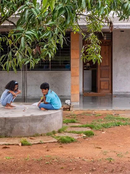 The farmhouse was designed to be inconspicuous and uncomplicated, nestled among the mango trees. The material palette of raw cement, earth, and stone borrows shades from the surroundings, rooting the architecture in its place.
