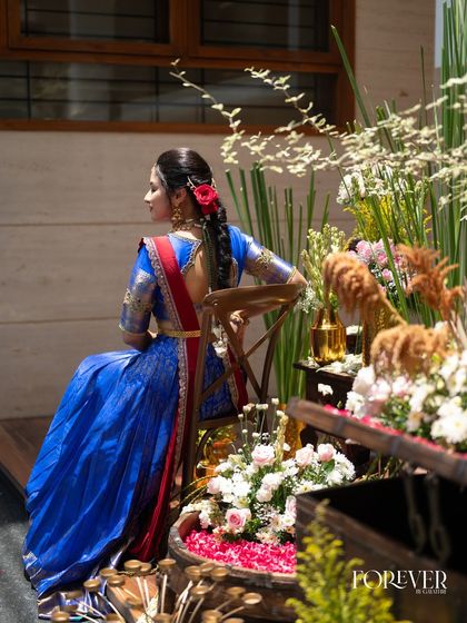 A back view showcasing the elegant braided hairstyle decorated with flowers and hair ornaments.