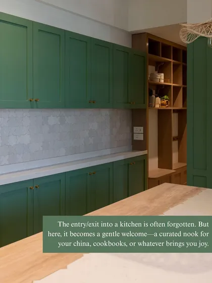 The entry into a kitchen is often overlooked. Here, it becomes a gentle welcome with a curated open shelving unit for china, cookbooks, or whatever brings you joy, blurring the line between the kitchen and the rest of the home.