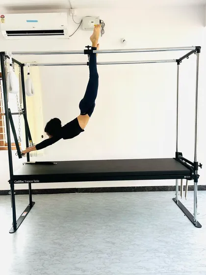 Hanging from the trapeze bar to build grip strength and engage the lats and core muscles.