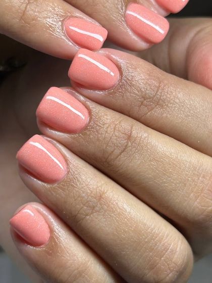 A lovely coral-pink manicure on short, natural nails. This bright and cheerful shade is perfect for summer or anytime you need a pop of color.