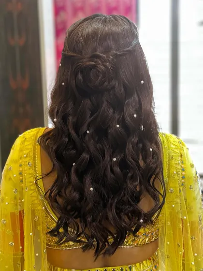 A half-updo with a rose made of hair, and soft waves dotted with pearls.