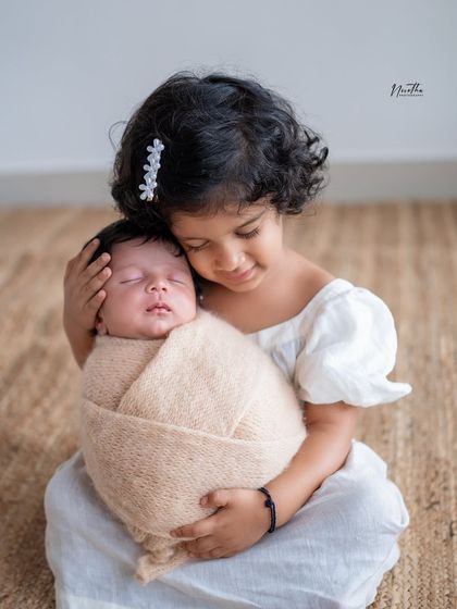 The first embrace between siblings. Capturing the gentle curiosity and love of an older sibling for their new baby brother or sister is always a special moment.