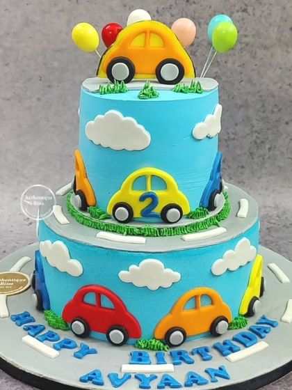 A fun two-tiered cake decorated with colorful cars driving on a winding road, perfect for a young car enthusiast.