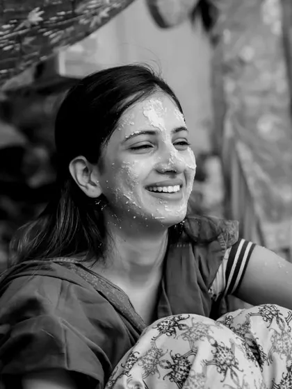 The pure joy of a Haldi ceremony captured in a timeless black and white photograph. Her radiant smile says it all, a moment of sheer happiness surrounded by loved ones.