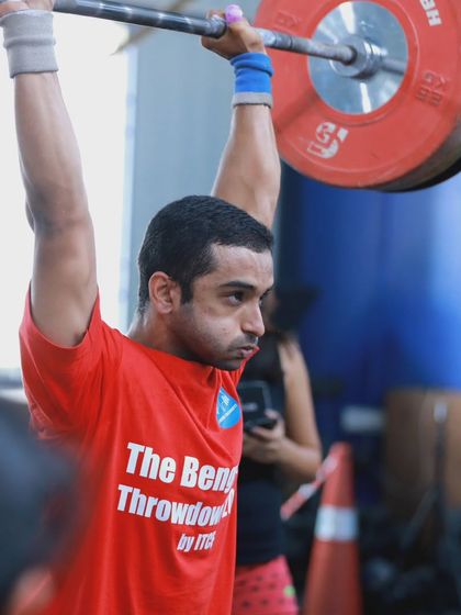 The focus and determination required for a heavy lift during competition. This athlete is locked in, ready to execute a perfect shoulder-to-overhead.