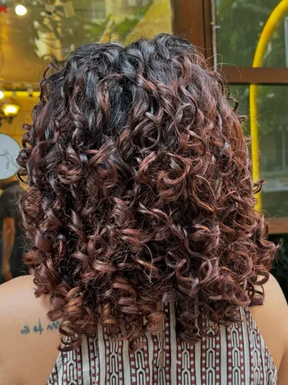 From frizzy and faded to defined and vibrant. This transformation included a no-bleach balayage to refresh her old color and a shaping cut to bring her curls back to life.