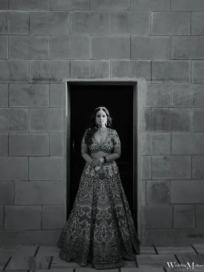 A timeless black and white portrait of the bride standing in a doorway. The contrast and composition give this photo a classic, cinematic feel.