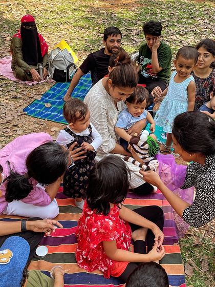 Another angle of the children captivated by the hand puppet. This kind of tactile interaction makes the storytelling experience more memorable and fun for toddlers and young kids.