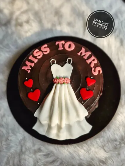 From Miss to Mrs! This rich chocolate cake is the perfect treat for a bride-to-be. The centerpiece is an elegant, edible wedding dress, symbolizing the exciting journey ahead.