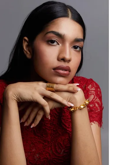 A simple, elegant portrait from a model test shoot. The focus is on the model's direct gaze and the texture of the red lace top, making it a strong image for a fashion or beauty portfolio.