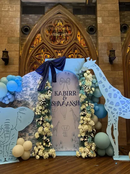For the arrival of twin boys, we created an elegant animal-themed decor using a sophisticated blue and white toile pattern as a backdrop, paired with custom animal cutouts.