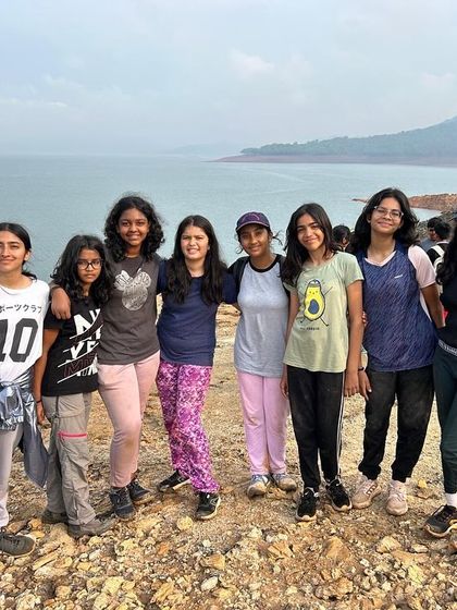 A group of girls poses together by the water, showcasing the strong bonds formed at camp.
