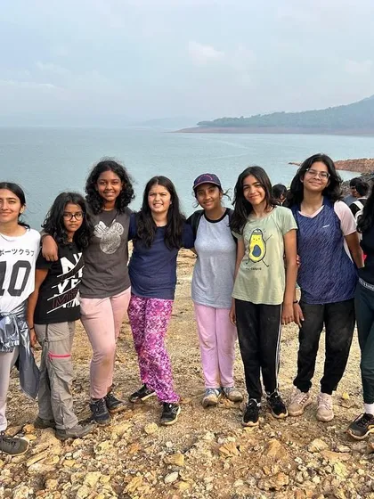 A group of campers stands together by the water, a testament to the friendships and bonds created at our camps.