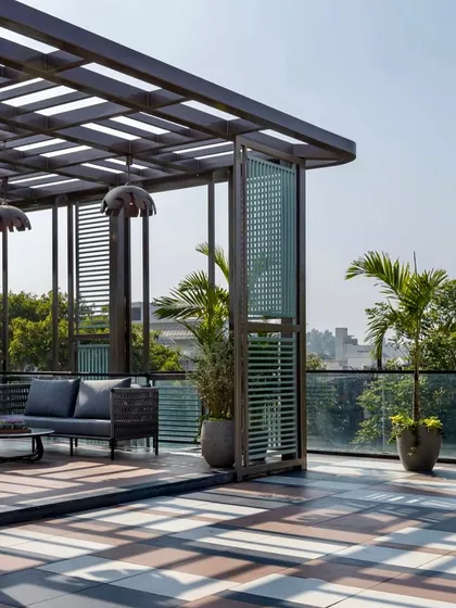 The play of light and shadow from the pergola adds a dynamic element to this Faridabad terrace throughout the day. The open-sided design maintains a sense of spaciousness while defining the lounge area.