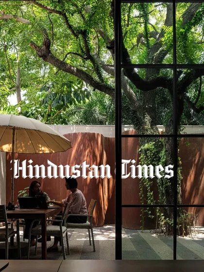 A feature in Hindustan Times discussing biophilic design, showcasing the courtyard at KEUS where employees can work or relax under a large tree, surrounded by nature.