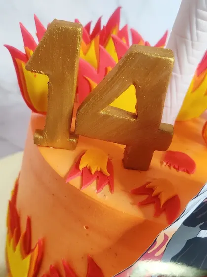 A close-up of the golden '14' and the handcrafted sugar flames on the Demon Slayer cake.