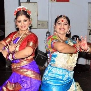 Two dancers in traditional Bharatanatyam attire, ready for a performance. We guide students on all aspects of a performance, including costume, makeup, and stage etiquette.