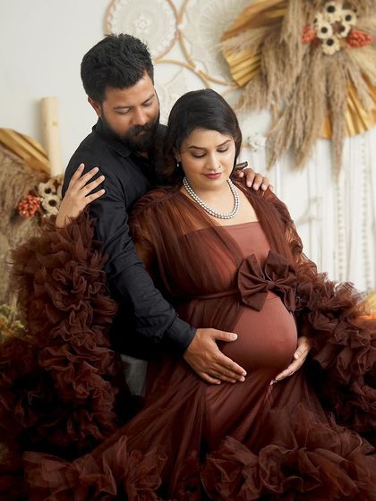 An intimate moment between expecting parents. The dad-to-be gently holds the baby bump, a simple gesture full of love and anticipation.