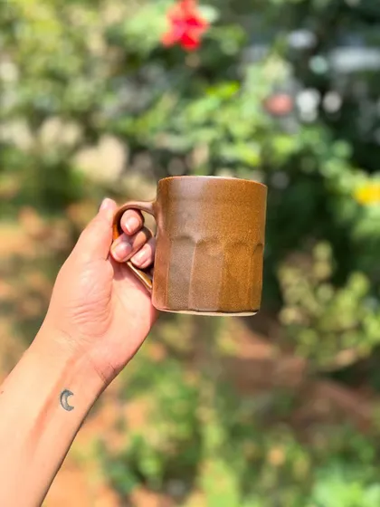 Holding one of our Languid Magic mugs. The faceted texture provides a comfortable and secure grip.
