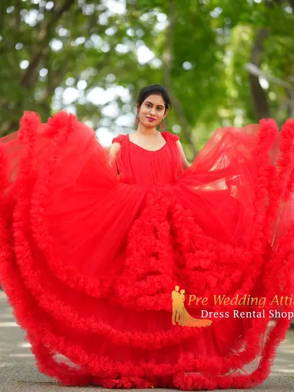 My collection includes high-fashion pieces like this vibrant red ruffled gown. The layers of soft tulle create incredible volume and texture, adding a sense of movement and playfulness to your photos. It's a fantastic choice if you want your outfit to be fun and memorable.