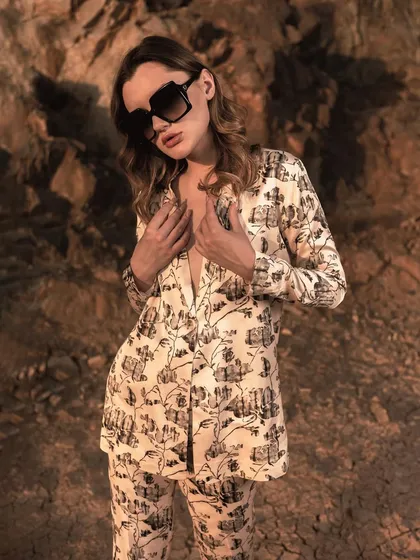 This image captures a candid, intimate moment, drawing attention to the V-neck detail of the blazer. It adds a layer of personality and relatability to the fashion lookbook.