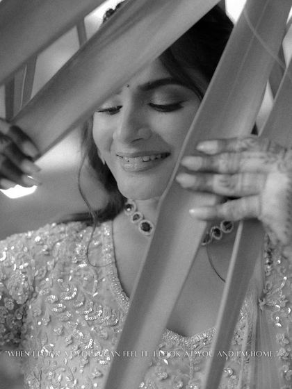 A creative black and white portrait of the bride. Peeking through leaves, her serene smile is captured in this artistic and intimate shot.