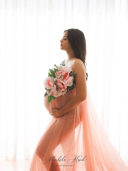 Soft, ethereal, and full of light. This portrait uses a delicate pink tulle gown and a bouquet of peonies to create a sense of gentle, blooming love against a backlit window.