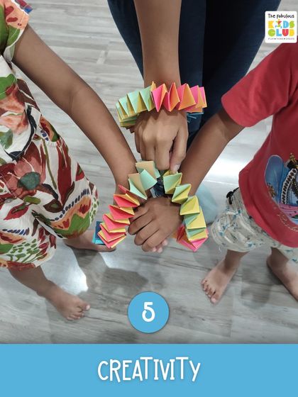 Creativity in action. These children are showing off the colorful bracelets they made together, a perfect example of how our art activities also foster teamwork and a sense of shared accomplishment.