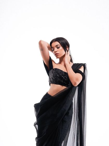 A classic and elegant pose, showcasing the modern black saree. The clean lighting and composition make this a versatile shot for any fashion campaign.