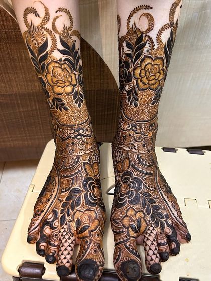 A full-coverage floral design for the feet. The bold, dark flowers and leaves create a stunning contrast, matching a heavy bridal hand design.