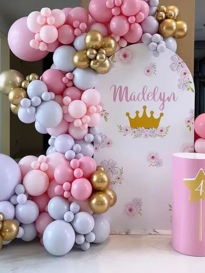 A princess theme fit for royalty. For Madelyn's fourth birthday, we designed this elegant backdrop with a custom name and crown decal, framed by a beautiful organic balloon garland in pastel pink, lilac, and gold.