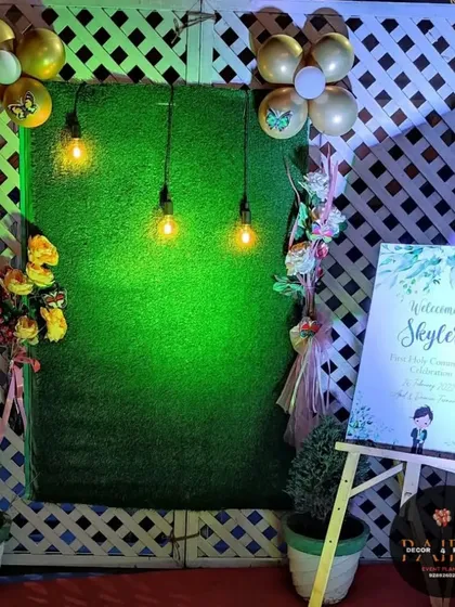 For a more modern and rustic theme, I created this backdrop using a green turf wall and a white lattice panel. The setup is completed with a personalized welcome easel, balloons, and warm Edison bulbs.