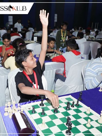 A young player raises his hand, a common sight in official tournaments to call for an arbiter. We teach our students the rules and etiquette of competitive chess.