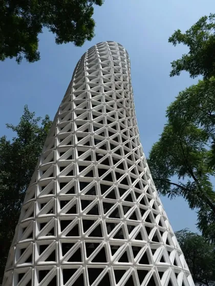 Looking up at the VERTO tower through a canopy of trees, this view highlights the product's verticality and its harmonious relationship with nature.