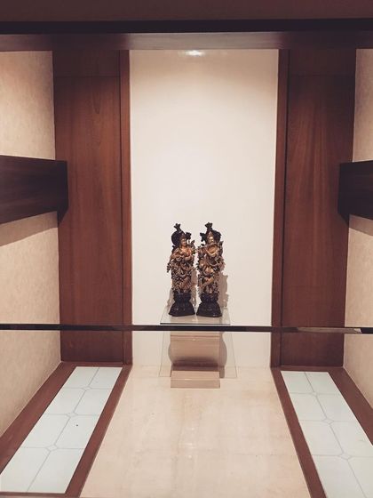 A beautifully designed niche to display traditional art pieces. The simple wood framing and focused lighting turn these statues of Radha and Krishna into a museum-quality exhibit.