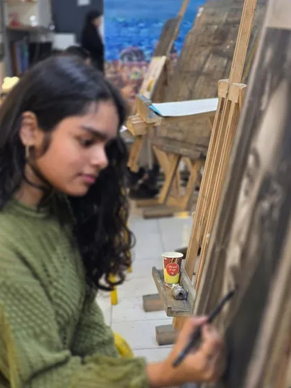 Another angle of the student working on her "shattered glass" portrait. This piece requires careful planning and execution to achieve the desired effect.