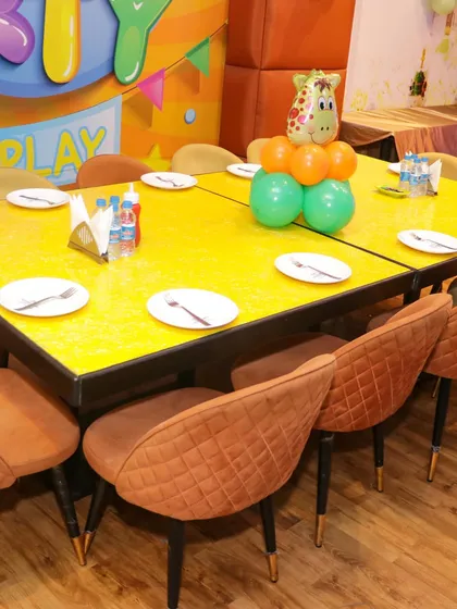 A decorated dining table for a jungle-themed party, featuring a giraffe balloon centerpiece to keep the fun going even during the meal.