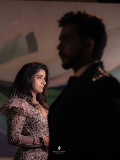 An artistic shot of the couple at their reception, with the groom's silhouette in the foreground.