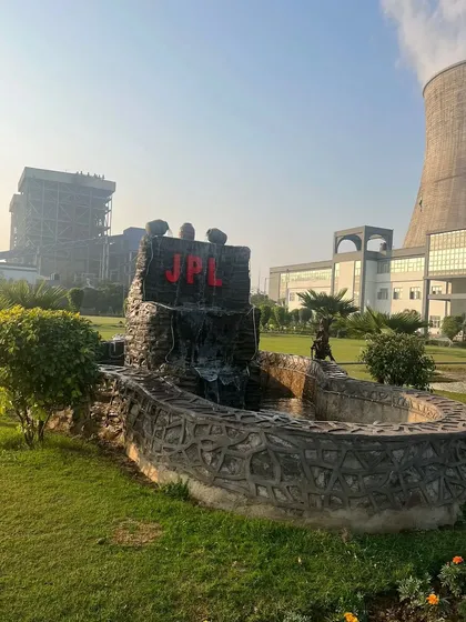 A custom water feature with the "JPL" logo, designed for the Jhajjar Power Limited campus. We incorporate bespoke hardscaping elements like fountains and rockeries into our large-scale projects.