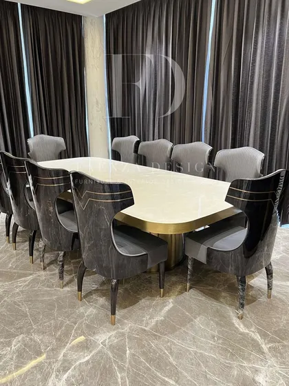 We believe the dining room is for making memories. This grand 10-seater dining set, featuring a polished onyx tabletop and uniquely designed chairs with gold accents, is crafted to be the centerpiece of your home's hospitality.