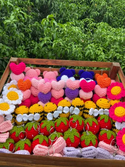 A little bit of everything in this crate. A colorful mix of heart, bear, bee, strawberry, and flower keychains for a custom wholesale order.