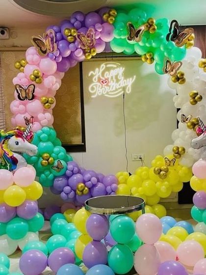 A magical unicorn and butterfly theme. This colorful balloon ring in pastel rainbow shades is adorned with unicorns and golden butterflies, creating a whimsical and enchanting photo backdrop.