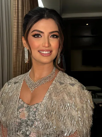A soft and glamorous look for a client attending a wedding, with face-framing pieces and an elegant updo.