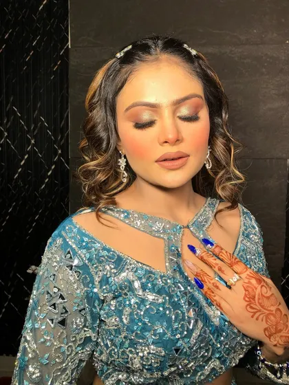 A detailed shot of the eye makeup and henna-adorned hand.