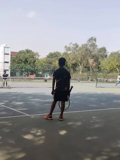 A young player prepares for his match during the TPL-ITA tournament. This image shows the on-court environment at our venue, where players compete on well-maintained hard courts.