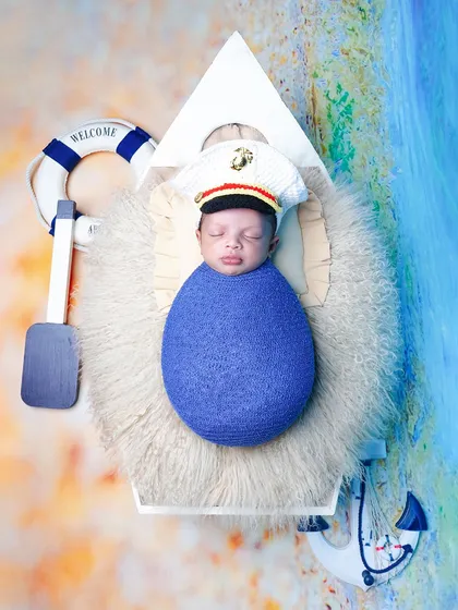 An overhead view of the nautical theme, with the baby dressed as a little captain in a boat, complete with a lifebuoy and anchor props.